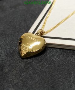 Gold heart-shaped pendant necklace on dark surface.