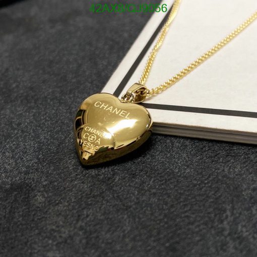 Gold heart-shaped pendant necklace on dark surface.