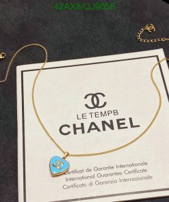 Chanel necklace with guarantee certificate on dark surface.