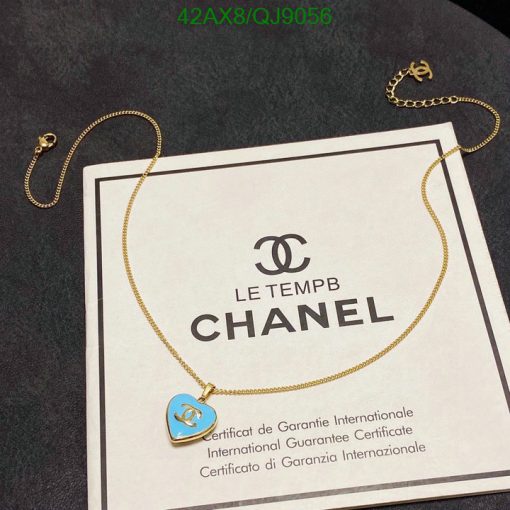 Chanel necklace with guarantee certificate on dark surface.