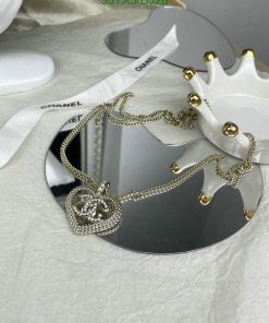 Designer necklace on display with branded packaging.