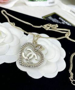 Silver heart pendant necklace on white petals.