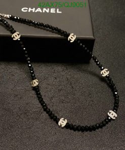 Black beaded designer-style necklace on box.