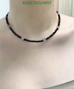 Black beaded choker necklace on woman's neck.