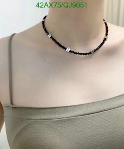 Person wearing a black beaded choker necklace.