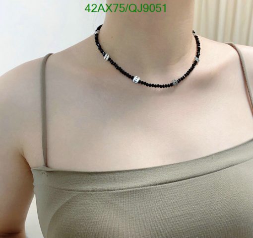 Person wearing a black beaded choker necklace.