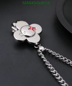 Silver flower-shaped keychain on dark background.