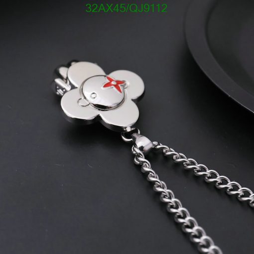 Silver flower-shaped keychain on dark background.