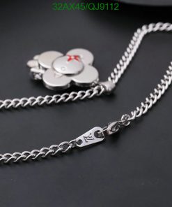 Silver flower pendant necklace on dark background.