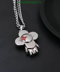 Silver teddy bear pendant with red bow detail.