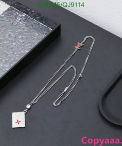 Silver necklace with red star pendant displayed on table.