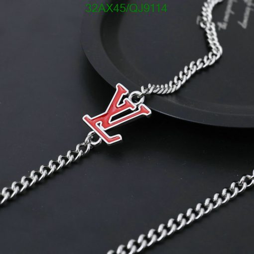 Silver chain necklace with red pendant.