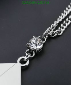 Silver chain necklace with diamond pendant on black background.