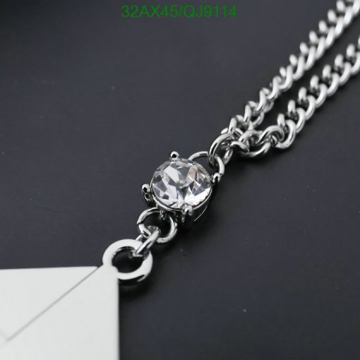 Silver chain necklace with diamond pendant on black background.