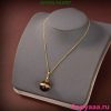 Gold pendant necklace on gray display stand.