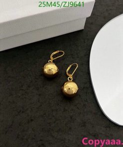 Gold ball dangle earrings on gray background.