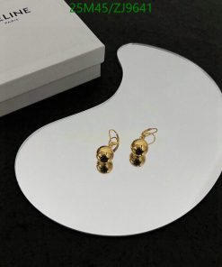 Gold earrings on white display with box in background.