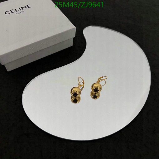 Gold earrings on white display with box in background.