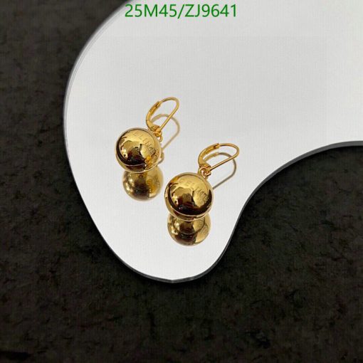 Gold round dangle earrings on white display.