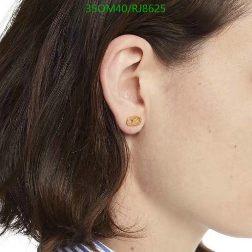 Woman wearing gold oval stud earring