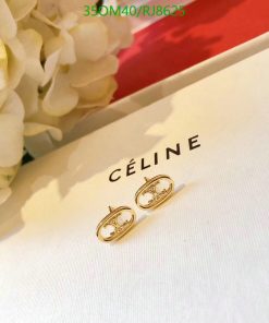 Gold hoop earrings on Céline brand packaging.