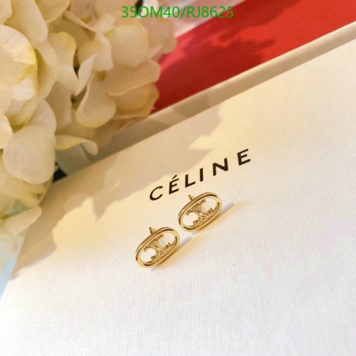 Gold hoop earrings on Céline brand packaging.