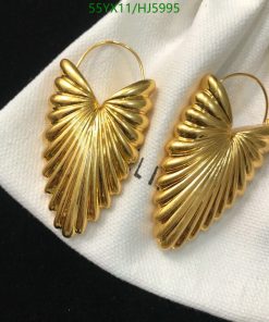 Gold leaf design dangle earrings on white cloth.