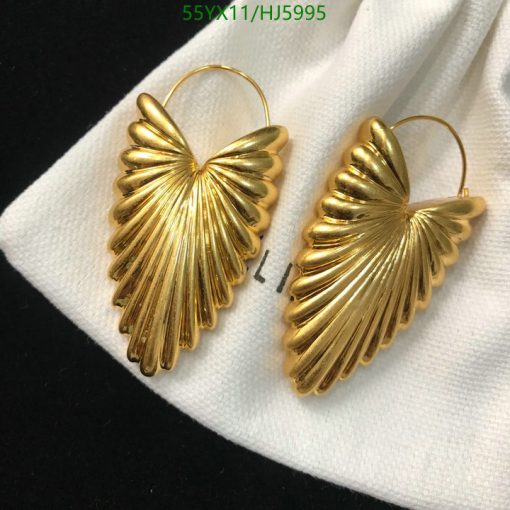 Gold leaf design dangle earrings on white cloth.