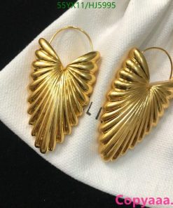 Gold butterfly wing earrings on white fabric.