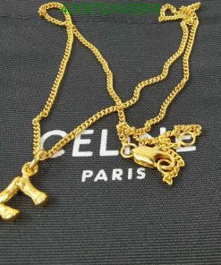 Gold necklace with Eiffel Tower pendant on black fabric.