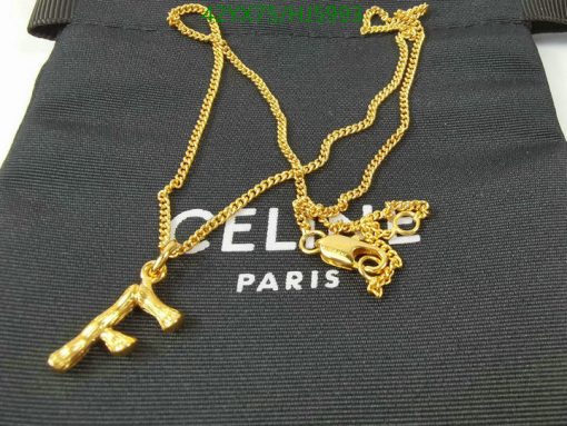 Gold necklace with Eiffel Tower pendant on black fabric.