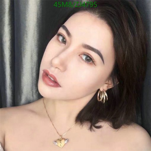 Woman with makeup, gold earrings, and necklace.