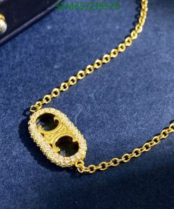 Gold necklace with diamond pendant on blue background.