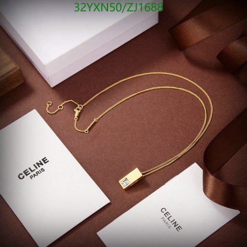 Gold necklace on brown background with luxury packaging.