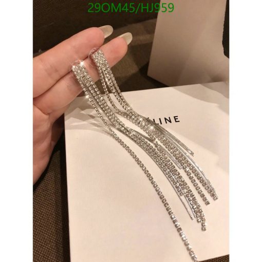 Hand holding sparkling long diamond earrings.