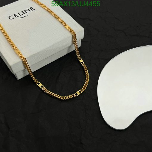 Celine gold chain necklace on black background with box.