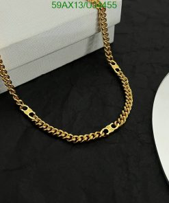 Gold chain necklace on dark background.