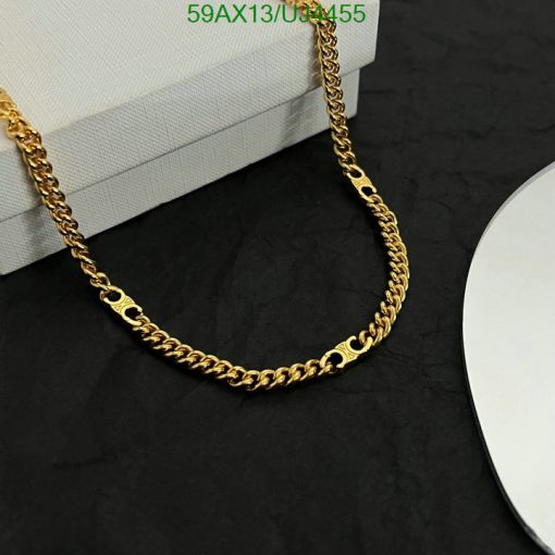 Gold chain necklace on dark background.