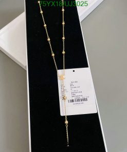 Gold necklace with tag on black display stand.