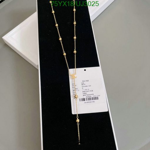 Gold necklace with tag on black display stand.