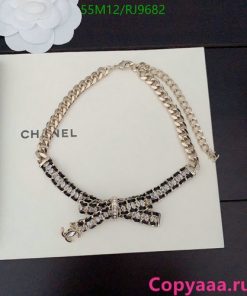 Chanel bow pendant necklace on book.