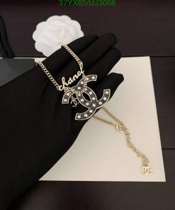 Elegant pendant necklace on black gloved hand.