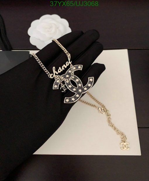 Elegant pendant necklace on black gloved hand.