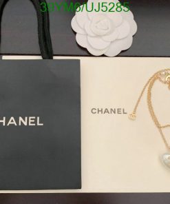 Chanel branded bag and necklace with pendant on display.