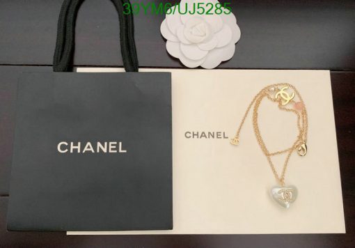 Chanel branded bag and necklace with pendant on display.