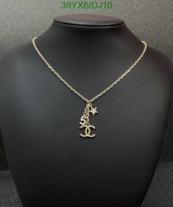 Gold anchor pendant necklace on black display.