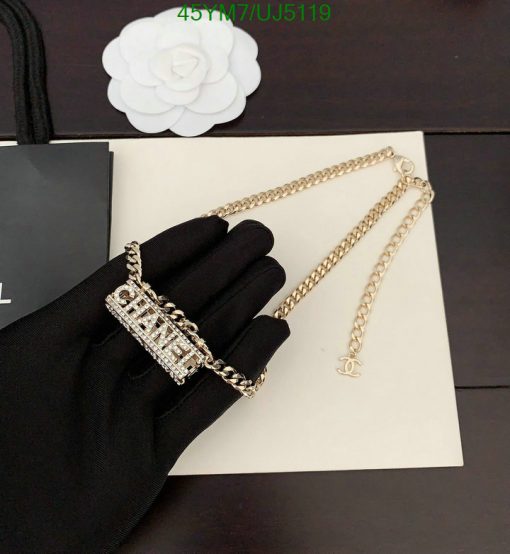 Hand wearing glove presenting a designer chain bracelet.