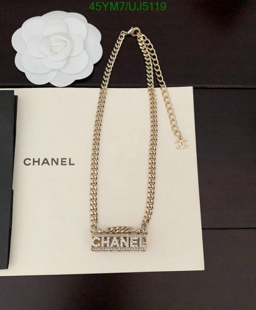 Gold chain necklace on branded box with flower decor.