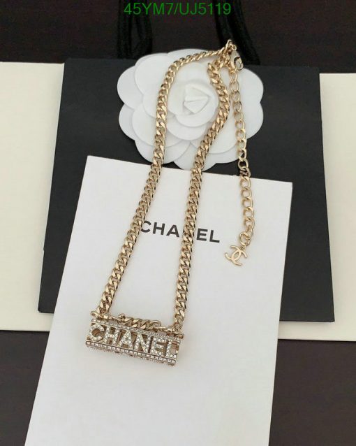 Gold chain necklace with logo pendant on display.