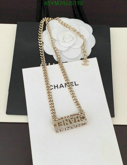 Gold chain necklace with pendant on branded bag.